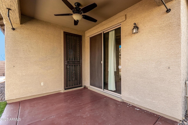 doorway to property with ceiling fan and a patio