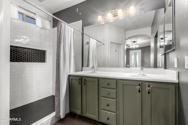 bathroom featuring walk in shower, vanity, and ceiling fan