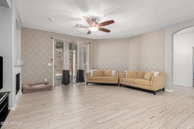 living room with light wood-type flooring and ceiling fan