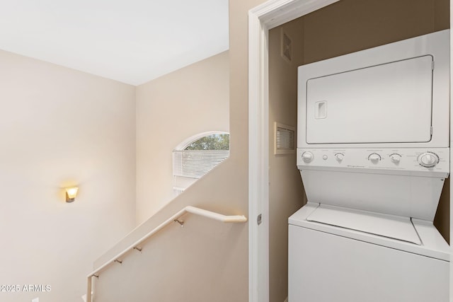 clothes washing area featuring stacked washer / dryer