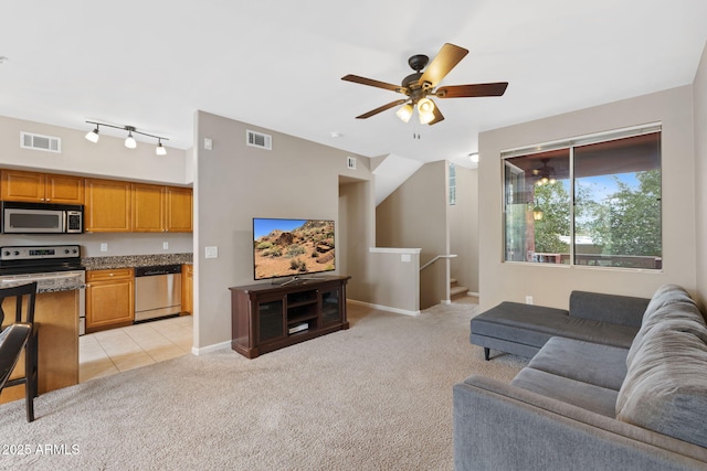 living room featuring rail lighting, light carpet, and ceiling fan