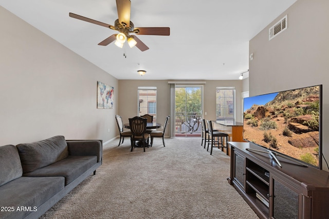 carpeted living room with ceiling fan