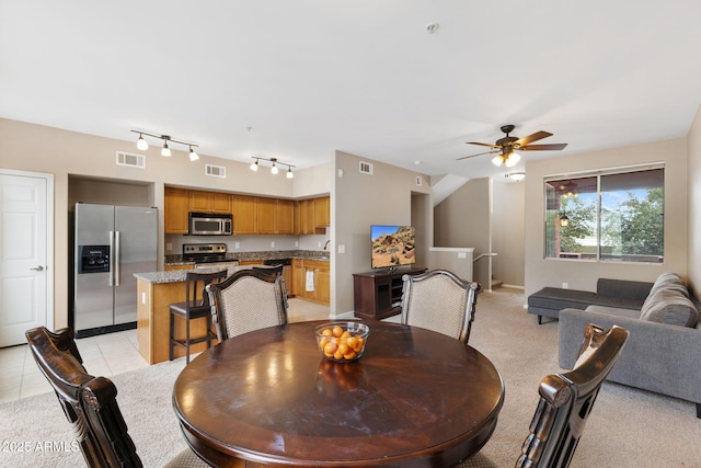 dining room featuring rail lighting, ceiling fan, and light tile patterned flooring