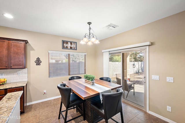 dining space featuring light tile patterned floors, baseboards, visible vents, and a notable chandelier