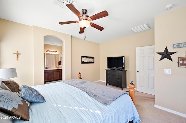 bedroom featuring arched walkways, visible vents, light carpet, and baseboards