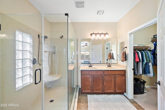 bathroom with a stall shower, visible vents, and a sink