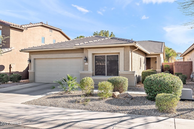 view of front facade with driveway, a garage, a tile roof, fence, and stucco siding