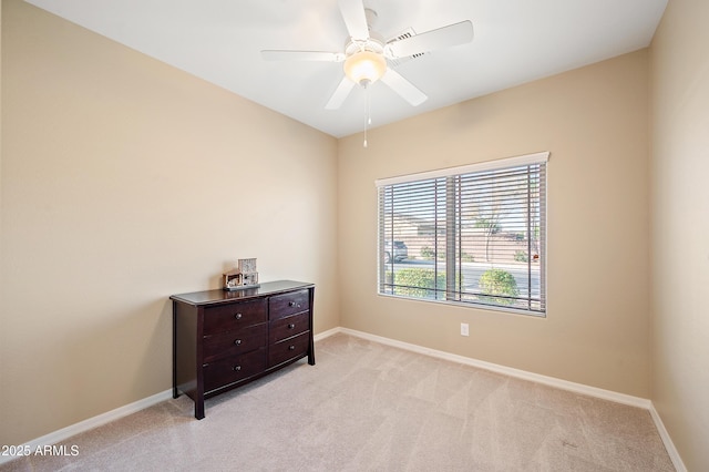 empty room with light carpet, ceiling fan, and baseboards