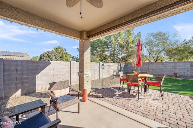 view of patio featuring outdoor dining area, a fenced backyard, and a ceiling fan