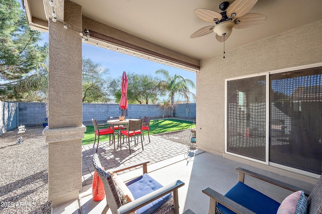 view of patio with outdoor dining area, a fenced backyard, and a ceiling fan