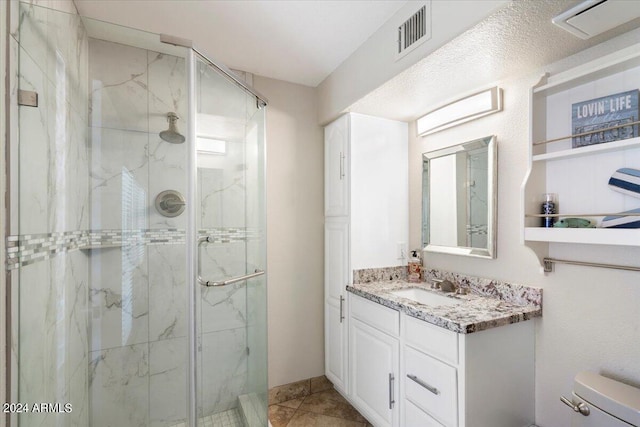 bathroom featuring an enclosed shower, a textured ceiling, vanity, tile patterned flooring, and toilet