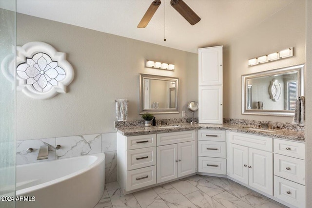 bathroom featuring a bathing tub, ceiling fan, vanity, and tile walls