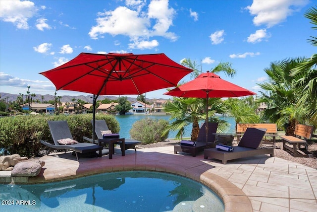 view of pool with a water view and a patio