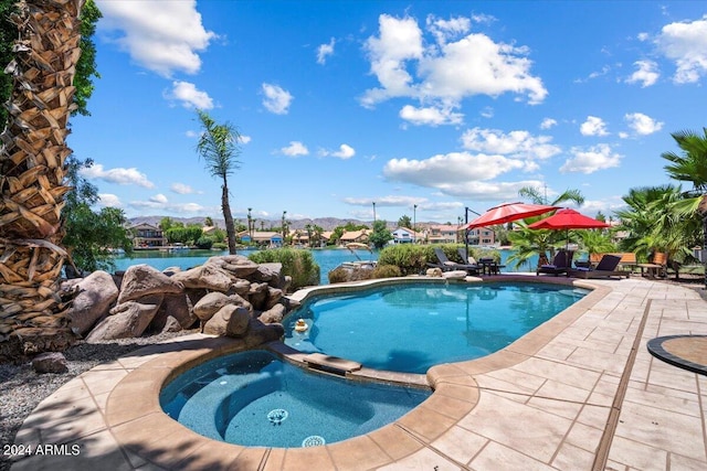 view of swimming pool with a patio area, an in ground hot tub, and a water view