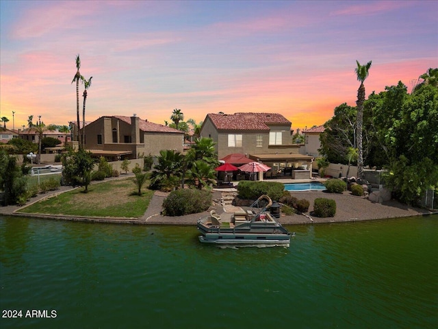 back house at dusk featuring a water view