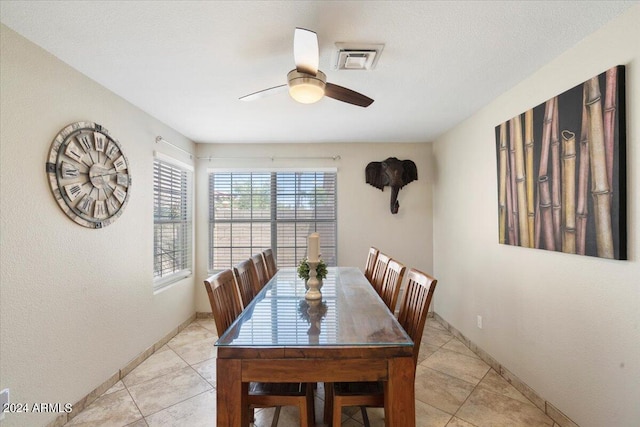 tiled dining space with ceiling fan