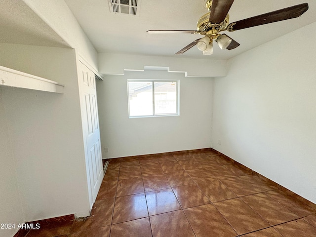 tiled empty room with ceiling fan