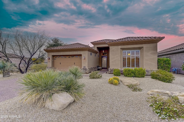 view of front of property featuring an attached garage, a tile roof, and stucco siding