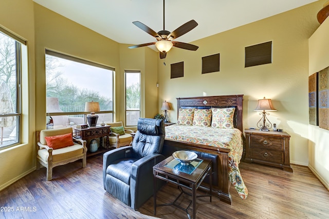 bedroom with hardwood / wood-style flooring, baseboards, and a ceiling fan