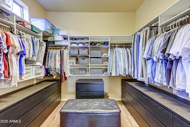 walk in closet with wood finished floors