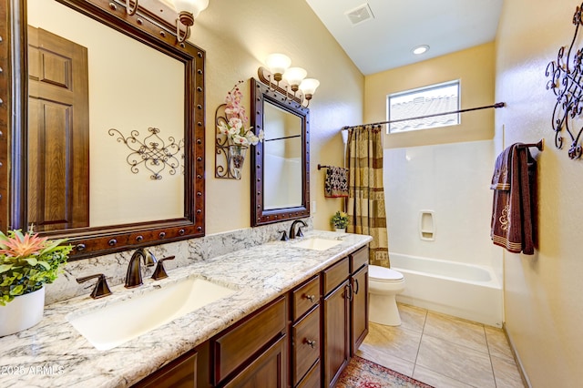 bathroom with visible vents, a sink, toilet, and double vanity