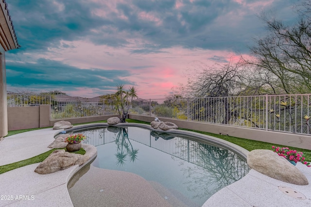 pool at dusk featuring a patio area and fence