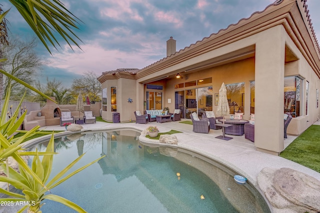 pool at dusk with fence, an outdoor hangout area, a fenced in pool, and a patio