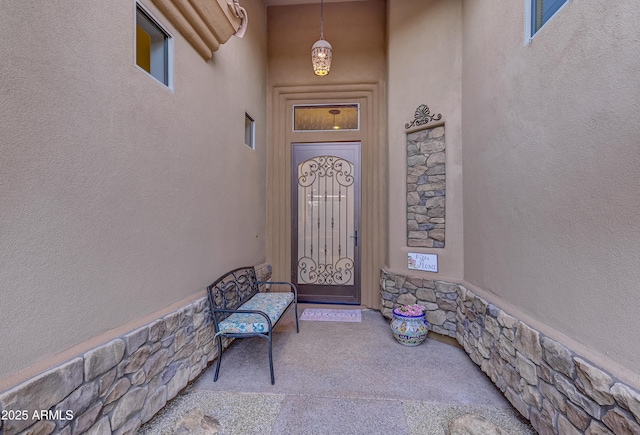 property entrance with stone siding and stucco siding