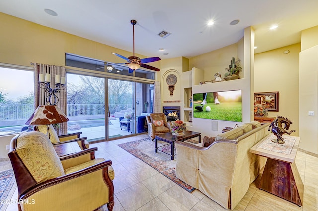 living room with light tile patterned floors, recessed lighting, visible vents, a ceiling fan, and a glass covered fireplace