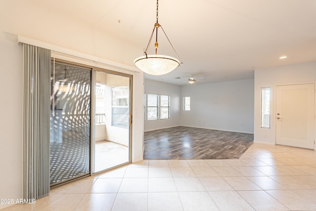 interior space with a ceiling fan and light tile patterned flooring