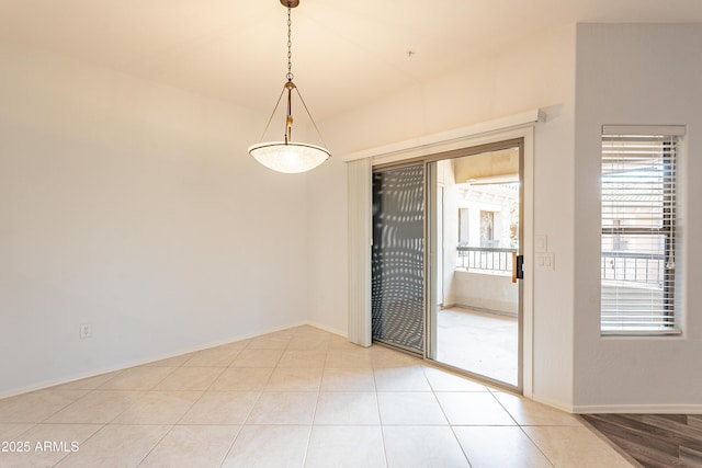 unfurnished room with baseboards and light tile patterned floors