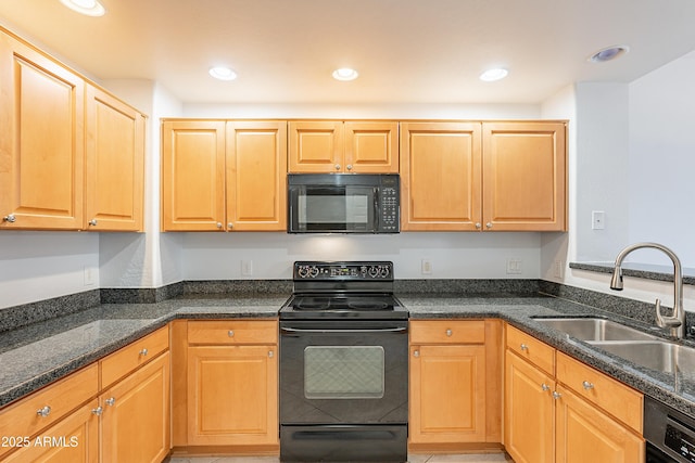 kitchen with dark stone countertops, recessed lighting, a sink, and black appliances