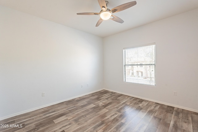 spare room with a ceiling fan, baseboards, and wood finished floors