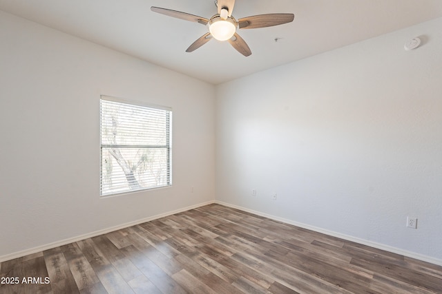 unfurnished room with a ceiling fan, dark wood finished floors, and baseboards