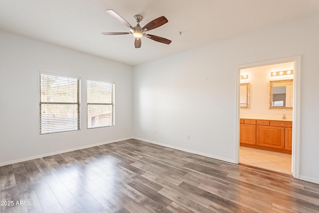 unfurnished room with light wood finished floors, baseboards, and a ceiling fan