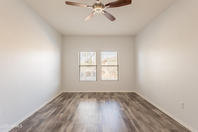 empty room featuring dark wood-style floors, baseboards, and a ceiling fan