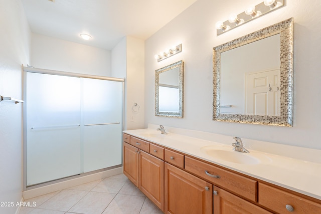 full bathroom featuring double vanity, tile patterned floors, a sink, and a shower stall