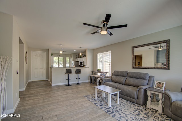 living room with ceiling fan and light hardwood / wood-style floors