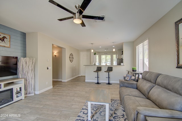 living room featuring light hardwood / wood-style flooring and ceiling fan