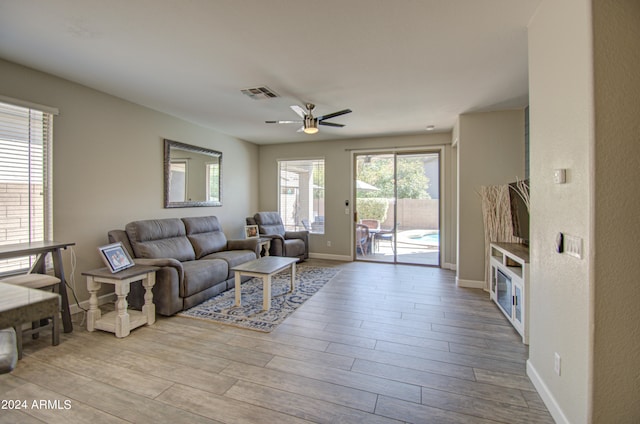 living room with light hardwood / wood-style flooring and ceiling fan