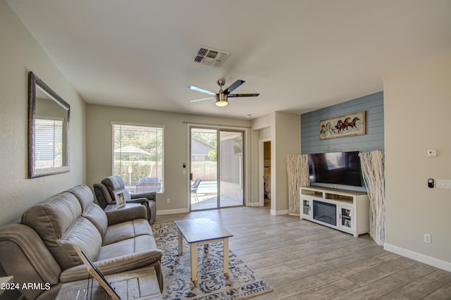 living room with light hardwood / wood-style flooring and ceiling fan