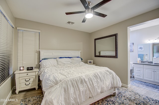 bedroom featuring ceiling fan, dark hardwood / wood-style floors, and ensuite bathroom