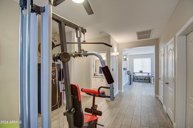 workout area with light hardwood / wood-style flooring and ceiling fan