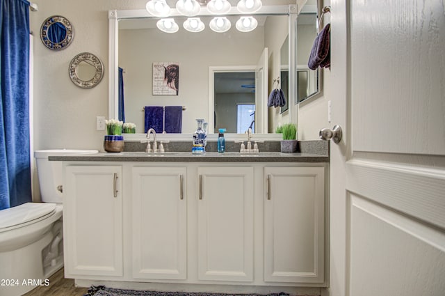 bathroom featuring toilet, hardwood / wood-style flooring, and vanity