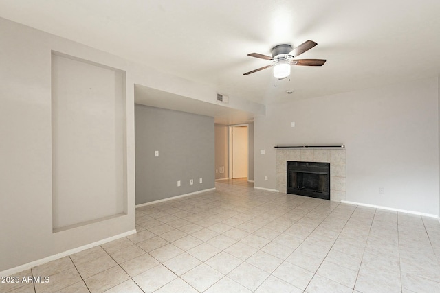 unfurnished living room with ceiling fan, light tile patterned floors, and a tiled fireplace