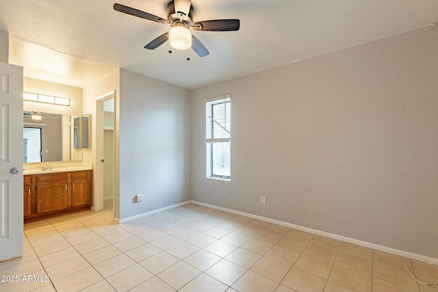 unfurnished bedroom with ensuite bath, ceiling fan, sink, and light tile patterned floors