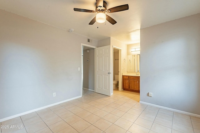 empty room with ceiling fan and light tile patterned floors