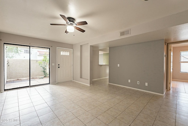 tiled empty room featuring ceiling fan