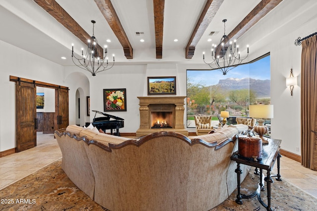 living room with beamed ceiling, a barn door, a mountain view, and a chandelier