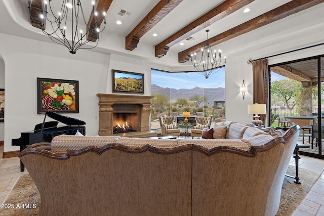 living room featuring beamed ceiling, a premium fireplace, a mountain view, and an inviting chandelier